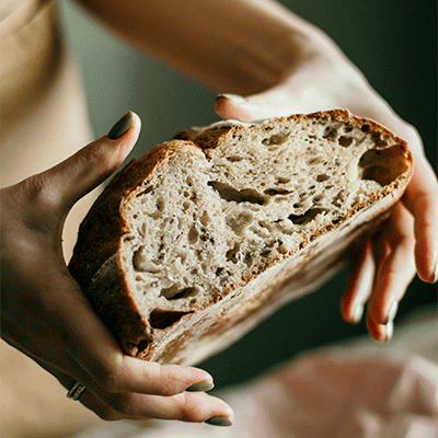 Half of a loaf of bread being held up to show the crumb